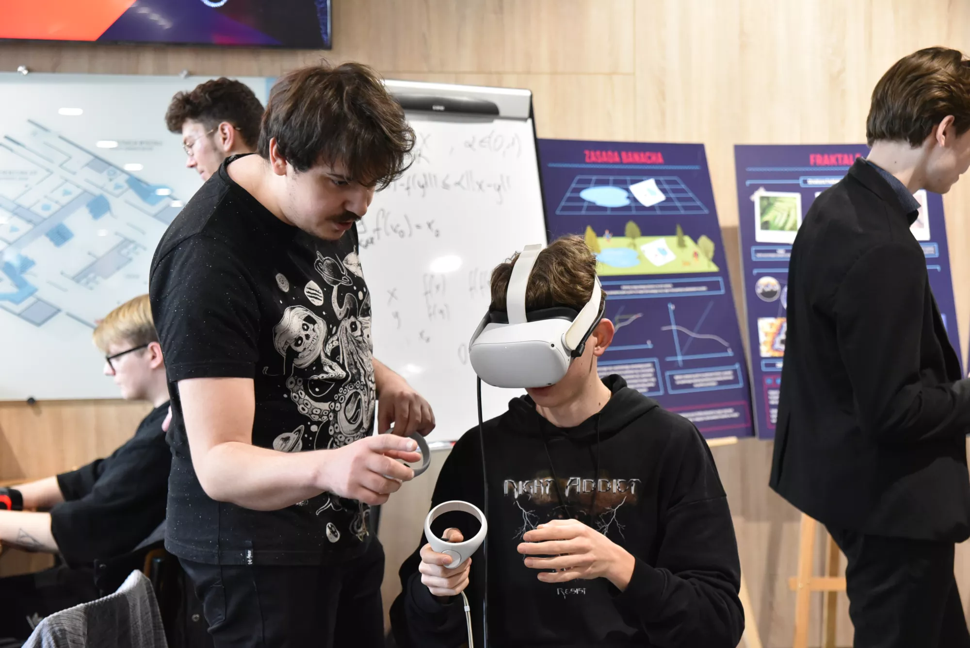 Uczniowie obsługują urządzenie VR.