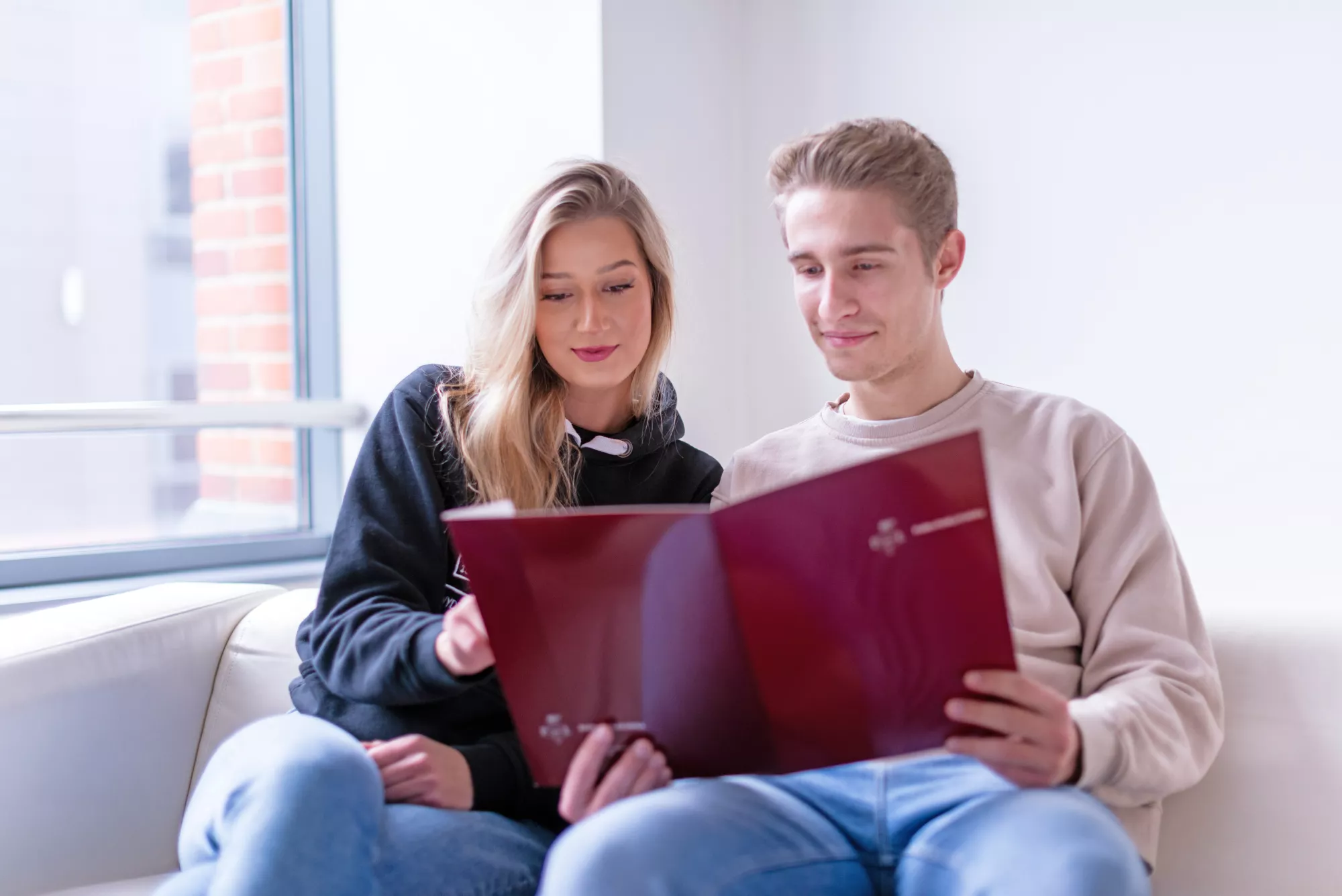 Dwoje studentów z teczką PŁ.